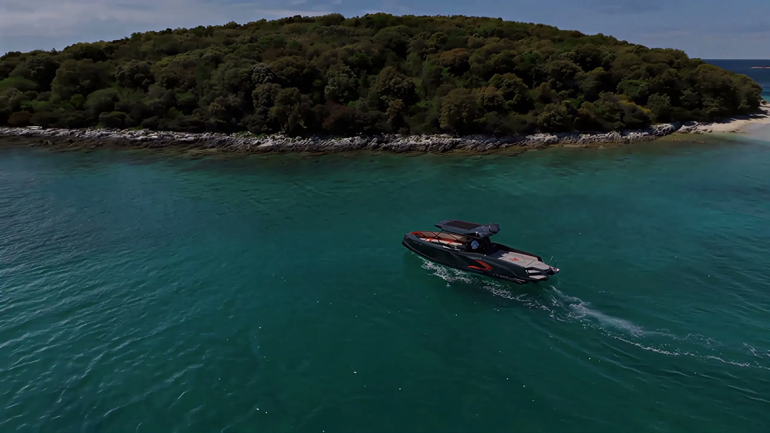 Lo yacht di Astyle Marine in navigazione davanti a un’isola boscosa, ripreso dall’alto